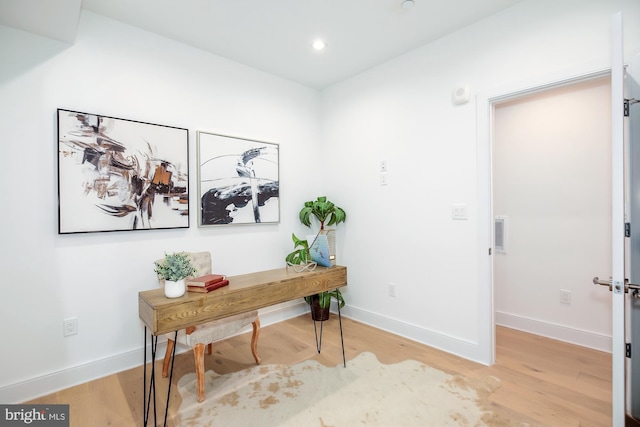 home office with light hardwood / wood-style flooring