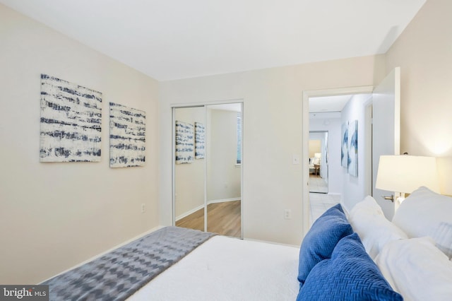 bedroom with light hardwood / wood-style flooring and a closet