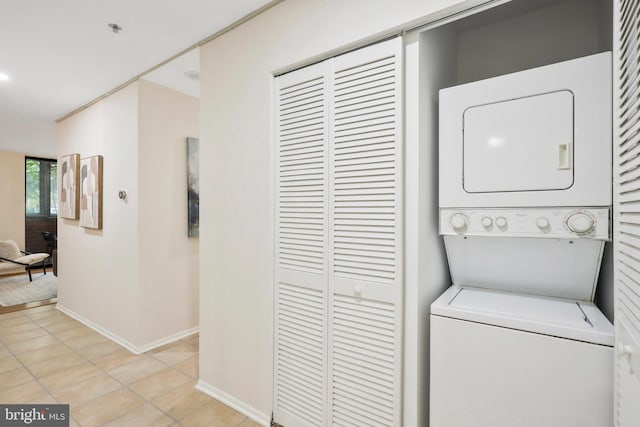 washroom featuring light tile patterned flooring and stacked washing maching and dryer