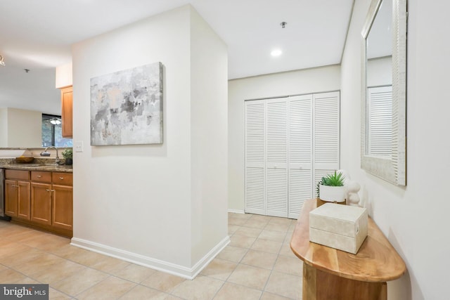 corridor featuring sink and light tile patterned floors