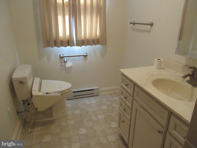 bathroom with tile patterned floors, a baseboard heating unit, vanity, and toilet