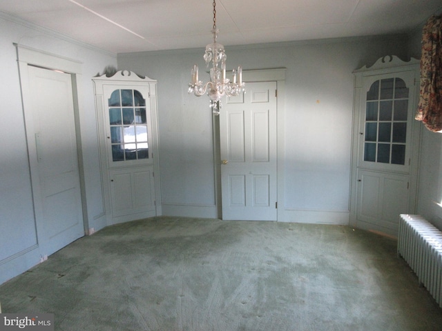 unfurnished dining area featuring carpet, radiator heating unit, and a chandelier