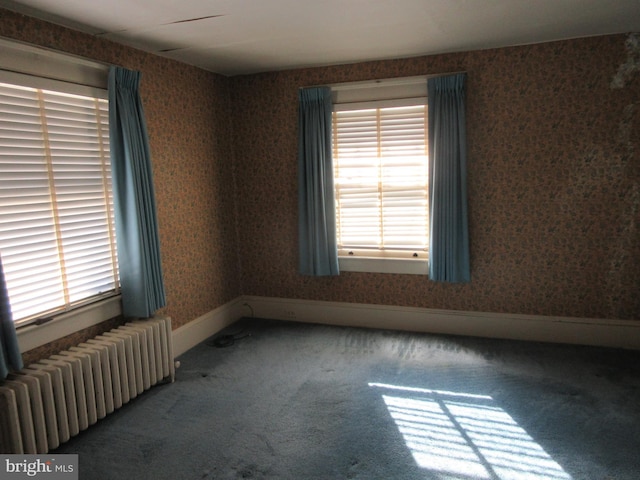 carpeted empty room featuring radiator