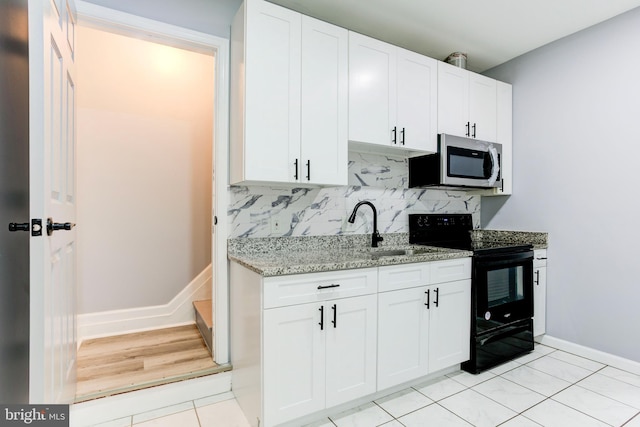 kitchen with white cabinetry, sink, tasteful backsplash, black electric range, and light tile patterned flooring