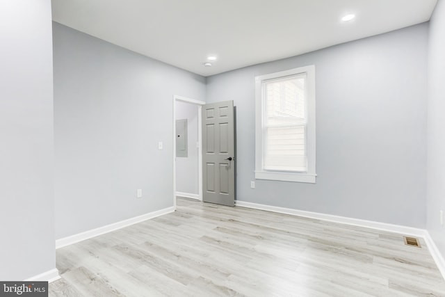 unfurnished room featuring electric panel and light wood-type flooring