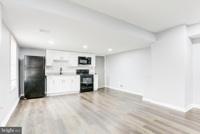 kitchen with light wood-type flooring, white cabinetry, and black appliances