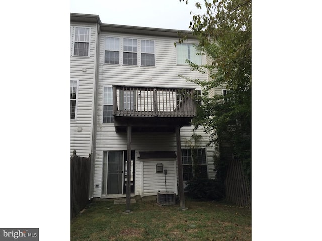 rear view of house with a lawn and a balcony