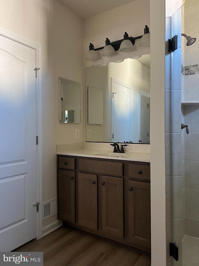 bathroom featuring vanity, hardwood / wood-style flooring, and walk in shower