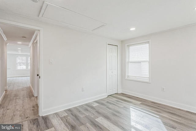 empty room featuring crown molding and light hardwood / wood-style flooring