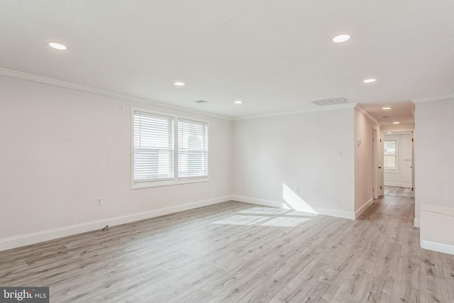 empty room featuring light wood-type flooring and ornamental molding