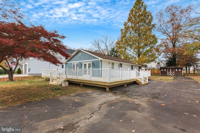 view of front of house with a deck and a storage unit