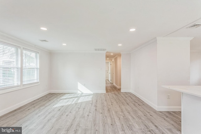 spare room featuring light wood-type flooring and ornamental molding