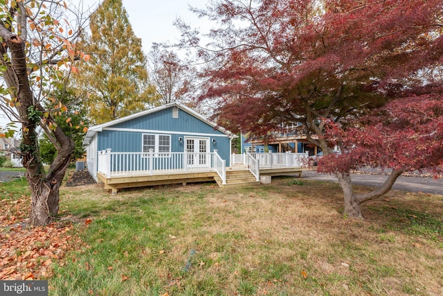 view of front of property with a wooden deck and a front lawn