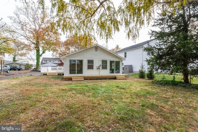 back of house featuring a yard and a wooden deck