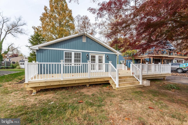 rear view of property with a lawn and a deck