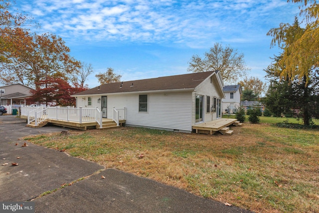 rear view of property with a yard and a wooden deck