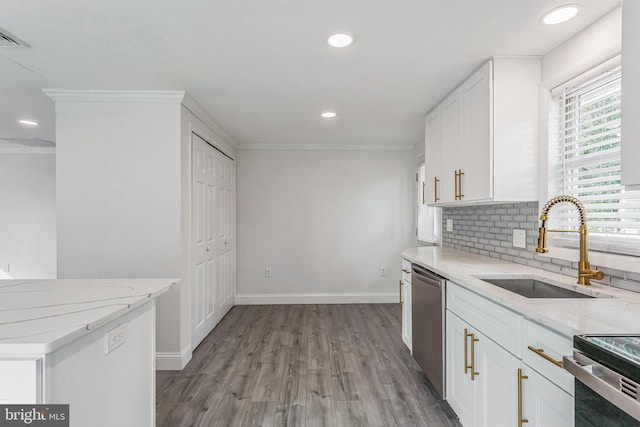 kitchen featuring light stone countertops, sink, stainless steel appliances, white cabinets, and light wood-type flooring