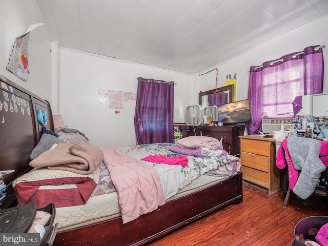 bedroom featuring crown molding and dark wood-type flooring