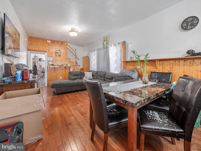 dining room with hardwood / wood-style floors and wood walls