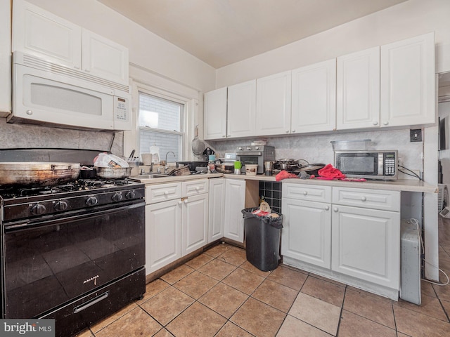 kitchen featuring white cabinets, light tile patterned floors, sink, and black range with gas cooktop