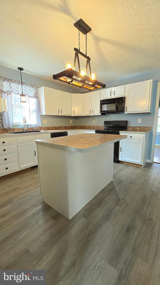 kitchen featuring pendant lighting, white cabinetry, black appliances, and dark wood-type flooring