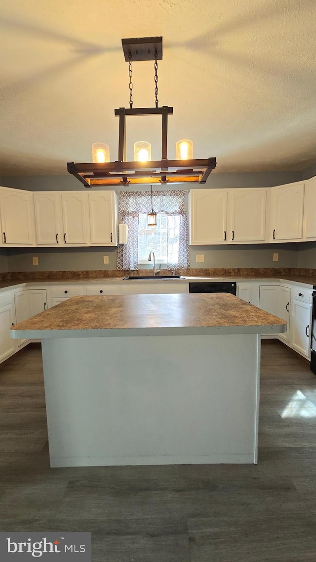 kitchen with white cabinets, a center island, decorative light fixtures, and dark hardwood / wood-style floors