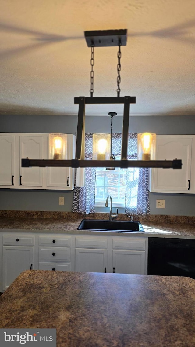 kitchen with dishwasher, white cabinetry, and sink