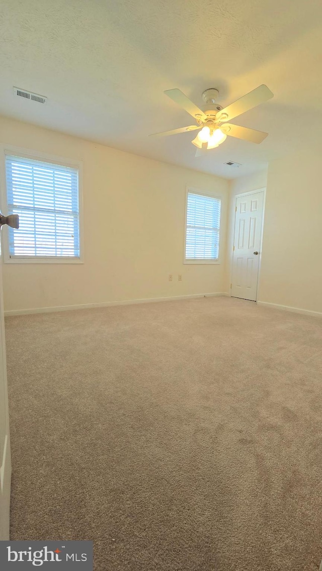 unfurnished room featuring ceiling fan and carpet floors