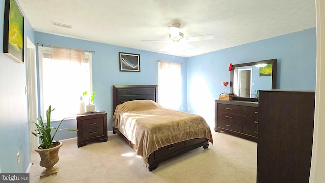 carpeted bedroom featuring a textured ceiling and ceiling fan