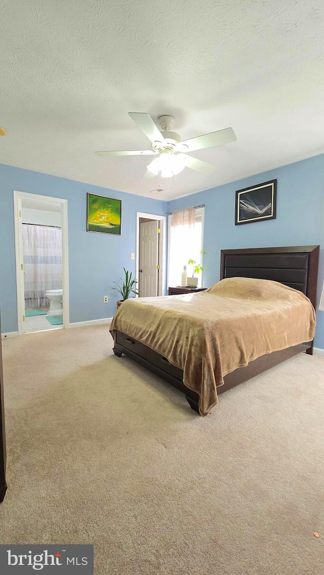 carpeted bedroom featuring ceiling fan, a textured ceiling, and connected bathroom