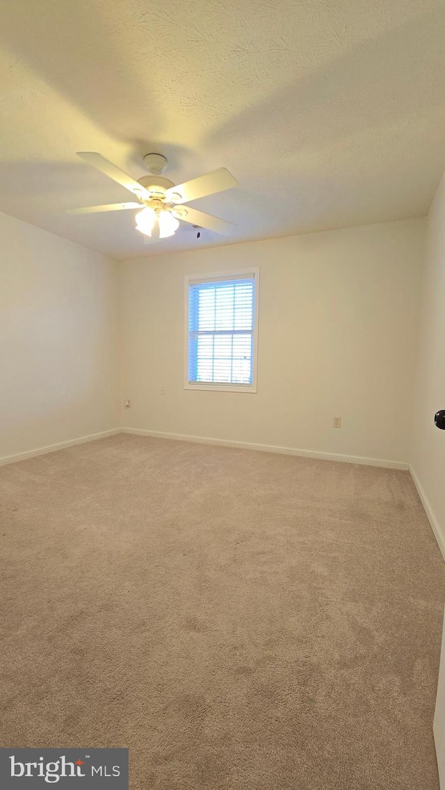 carpeted empty room featuring a textured ceiling and ceiling fan