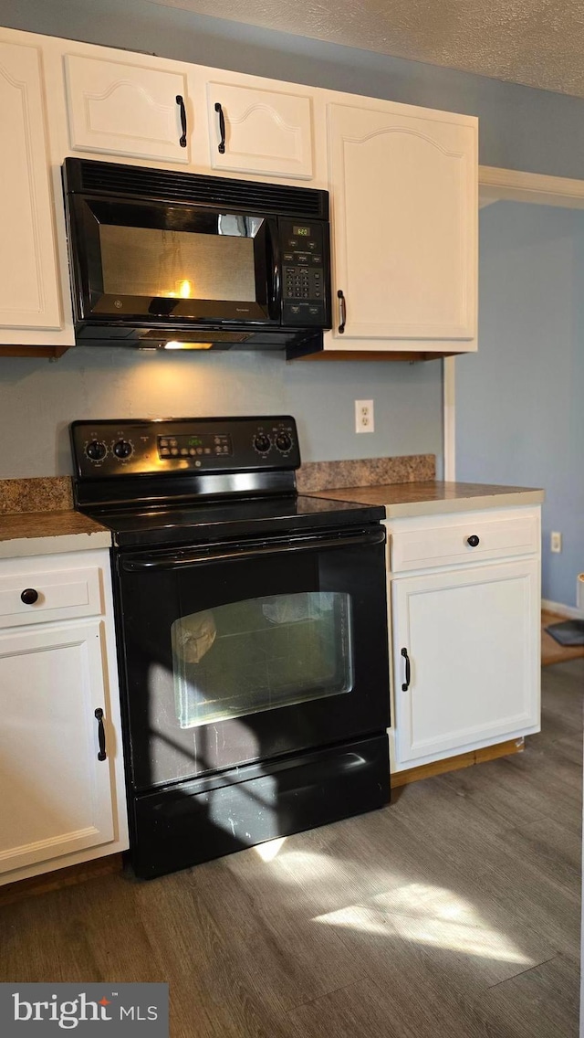 kitchen with black appliances, dark hardwood / wood-style flooring, white cabinets, and a textured ceiling