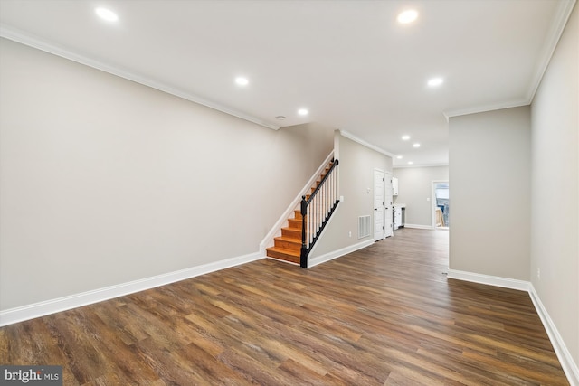 spare room featuring crown molding and dark wood-type flooring