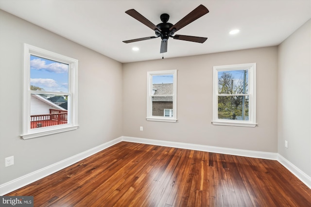 unfurnished room featuring dark hardwood / wood-style floors, ceiling fan, and a healthy amount of sunlight