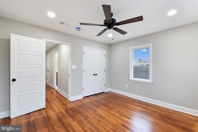 unfurnished bedroom featuring dark hardwood / wood-style floors and ceiling fan