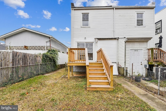 back of property with a lawn and a deck