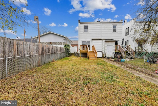 rear view of property featuring a wooden deck and a yard