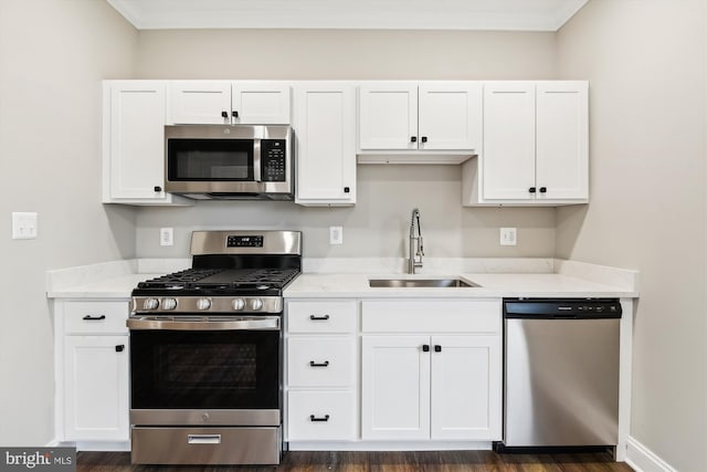 kitchen featuring sink, dark hardwood / wood-style floors, light stone counters, white cabinetry, and stainless steel appliances