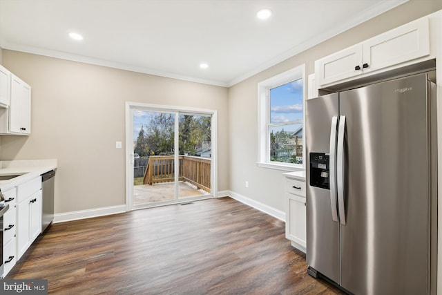 kitchen featuring white cabinets, stainless steel appliances, dark hardwood / wood-style floors, and ornamental molding