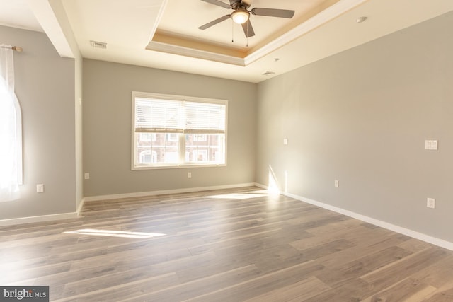 spare room with hardwood / wood-style floors, a tray ceiling, and ceiling fan