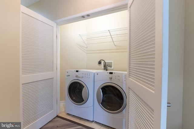 washroom with separate washer and dryer and light hardwood / wood-style flooring