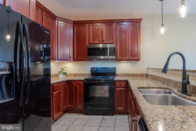 kitchen featuring light stone counters, sink, black appliances, decorative light fixtures, and light tile patterned flooring