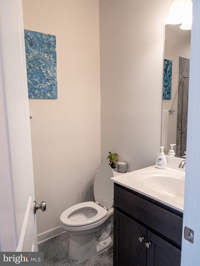 bathroom with tile patterned floors, vanity, toilet, and a shower