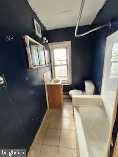 bathroom with a bathtub, tile patterned flooring, vanity, and toilet