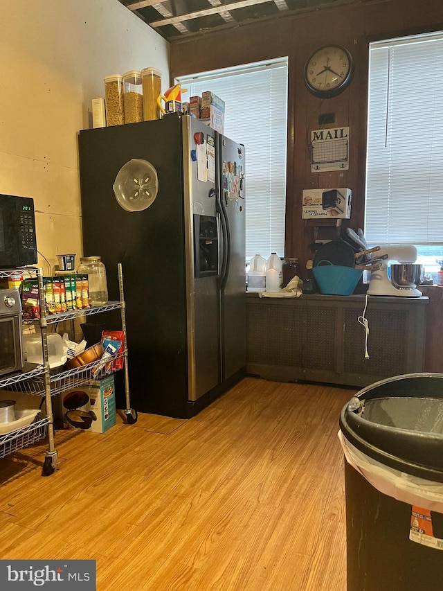 kitchen featuring stainless steel refrigerator with ice dispenser and light hardwood / wood-style flooring