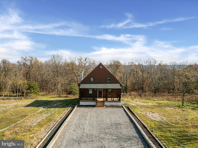 cabin featuring covered porch and a front lawn