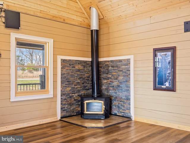 interior details featuring wood-type flooring, a wood stove, and wooden walls