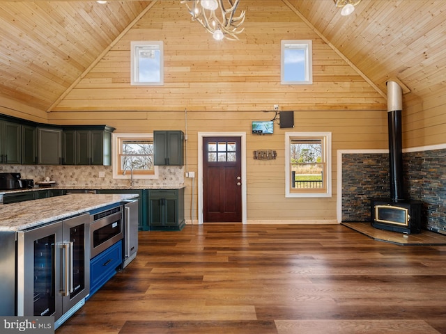 kitchen featuring high vaulted ceiling, wood ceiling, and wooden walls