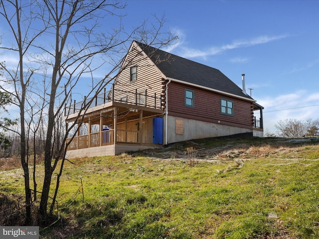 view of property exterior with a wooden deck and a lawn