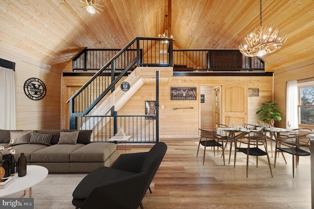 living room featuring a chandelier, wooden walls, hardwood / wood-style floors, and wood ceiling